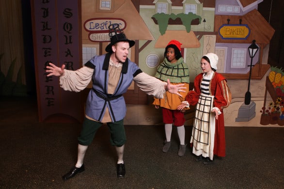 Matthew Pyle as Woolchester telling an exaggerated encounter with a dragon while Alia Sedlacek as Glaston and Amy Bahr as Darby listen. Photo courtesy The Rose