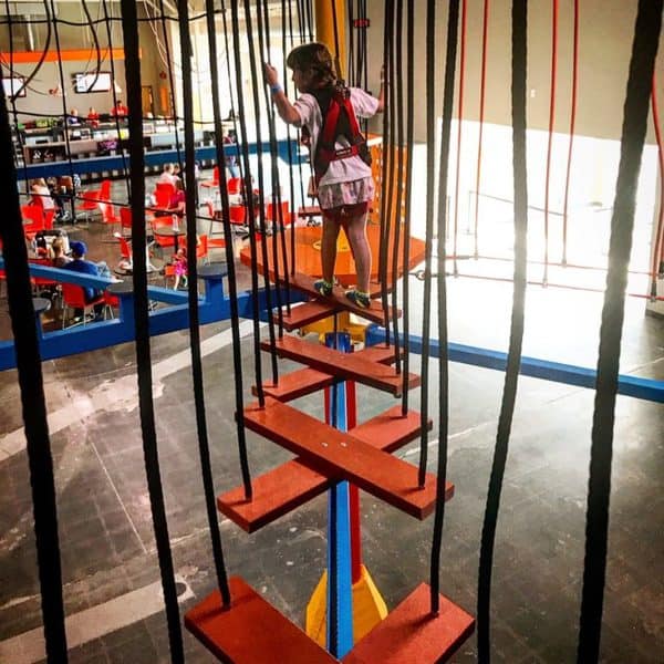 A girl on the ropes course inside Urban Air in Omaha
