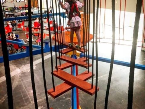 A girl on the ropes course inside Urban Air in Omaha
