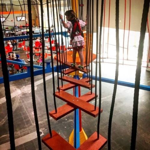 A girl on the ropes course inside Urban Air in Omaha