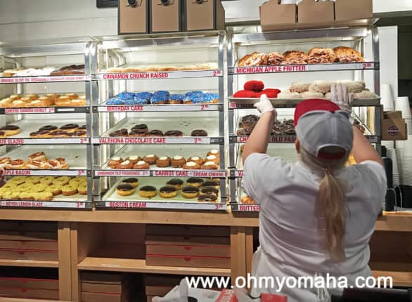 Employee adding more donuts to the display at Do-Rite Donuts in Chicago