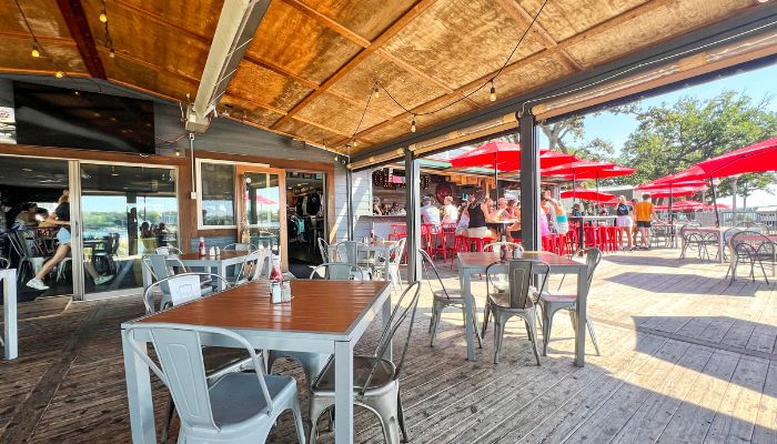 The patio at Okoboji Store Bar & Kitchen, with red umbrellas shading tables in the background