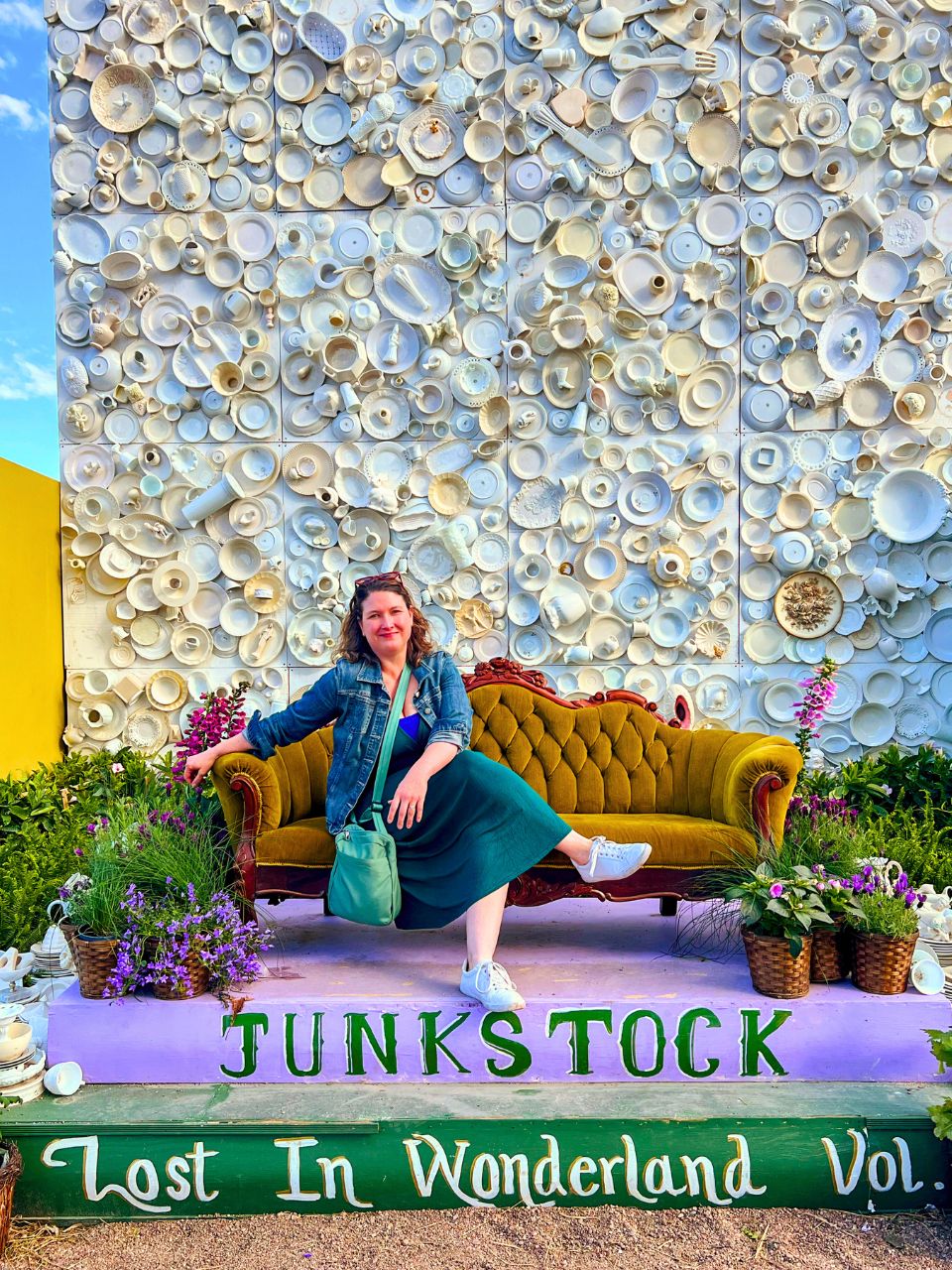 Kim sits on a velvet couch at the Lost in Wonderland-themed Junkstock photo ops