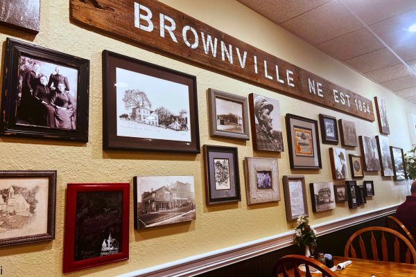 A wall filled with framed photos inside The Lyceum in Brownville, Nebraska