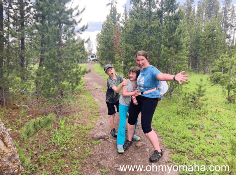 Family smiling after a rain-soaked hike in Yellowstone.