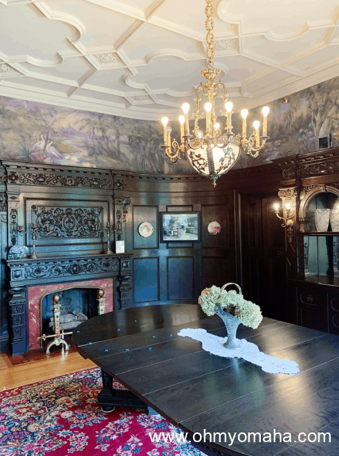 A dining room in Joslyn Castle featuring a fireplace and chandelier.