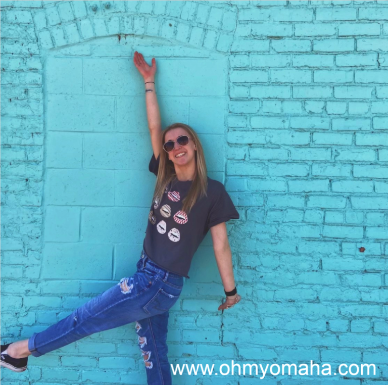 Girl in from of blue wall in North Omaha