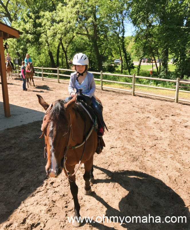 Girl wearing a helmet while on a horse
