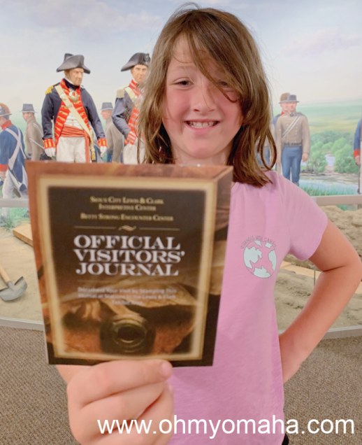 Girl holding a journal for stamping at the Lewis & Clark Interpretive Center