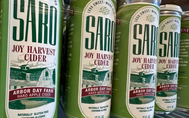 An up-close shot of cans of Saro Joy Harvest Cider, a special edition cider for Arbor Day Farm