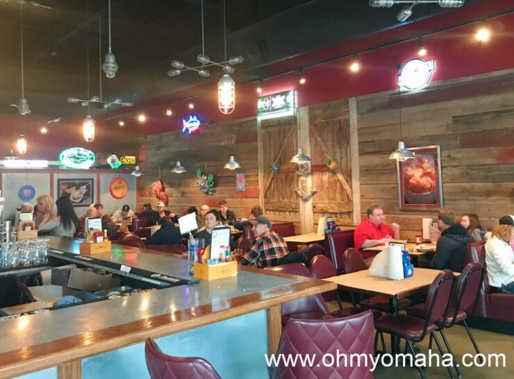 Dining room with a bar and booths at West Omaha location of Shucks