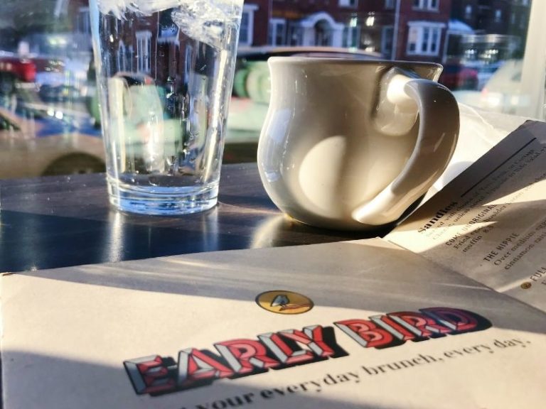 Early Bird menu with a glass of water and coffee mug in background