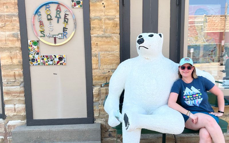 Kim with a white bear sculpture in Lucas, Kansas