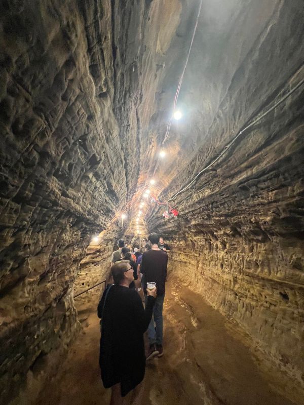 A tour walks down one of the man-made tunnels in Robber's Cave in Lincoln