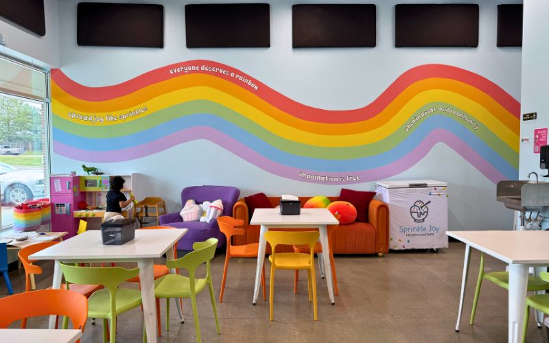 A rainbow mural on the wall of Happy Mango Bakery