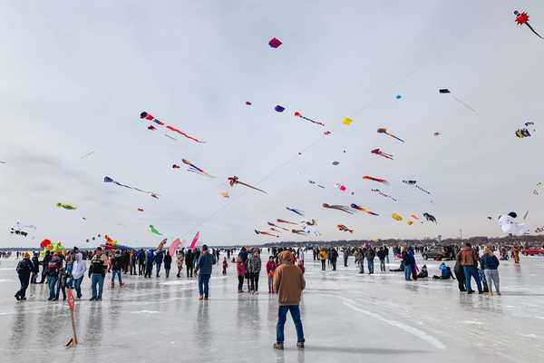 Dozens of kites fly over a frozen lake in Iowa
