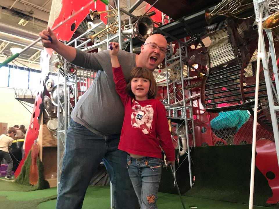 Dad and daughter posing on the putting green at Can Can Wonderland in St. Paul, Minnesota