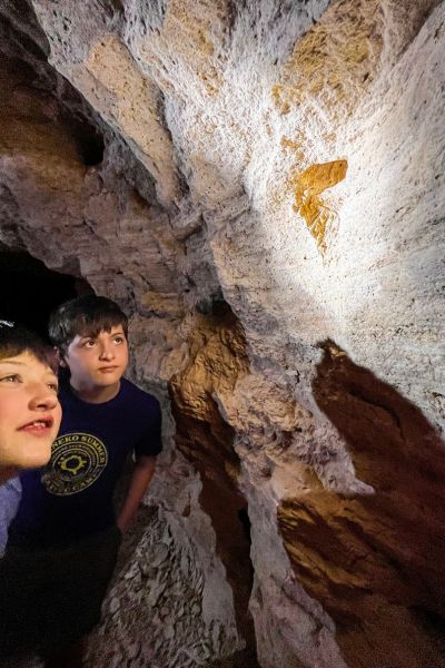 Kids look at a fossil imprint on the wall of the chalk mine in Nebraska