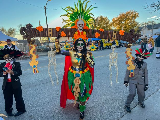 A girl dressed as a Catrina and two boys in costume pose for a picture in Kansas City, Kansas ahead of the Day of the Dead Parade