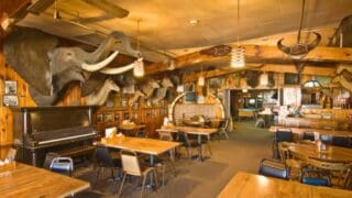 The dining room at Ole's Big Game Steakhouse in Paxton, Nebraska, with animal heads like an elephant's, on the walls