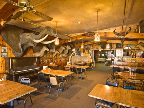 The dining room at Ole's Big Game Steakhouse in Paxton, Nebraska, with animal heads like an elephant's, on the walls