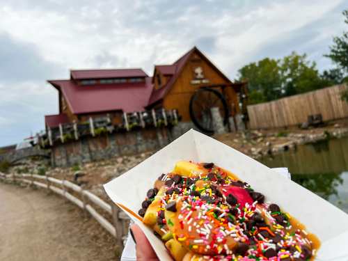 The Caramel Apple Boat at Vala's includes apples slices topped with caramel sauce and choice of toppings, including chocolate chips and sprinkles. In the background is the Cider Mill.