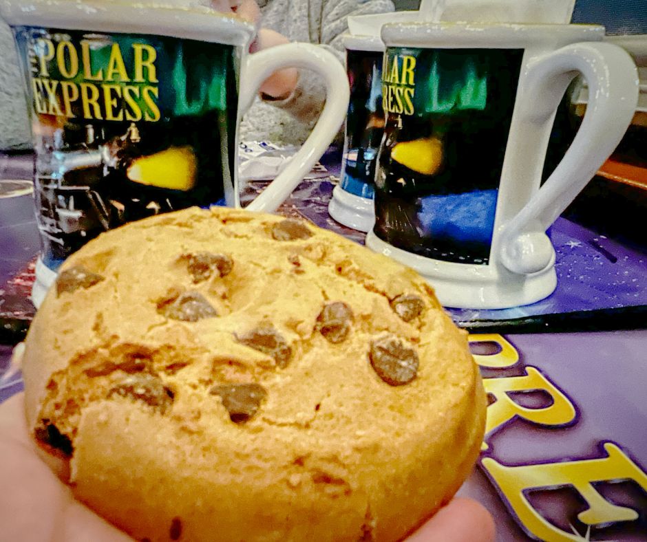 A chocolate chip cookie and souvenir mugs on The Polar Express Train Ride in St. Louis