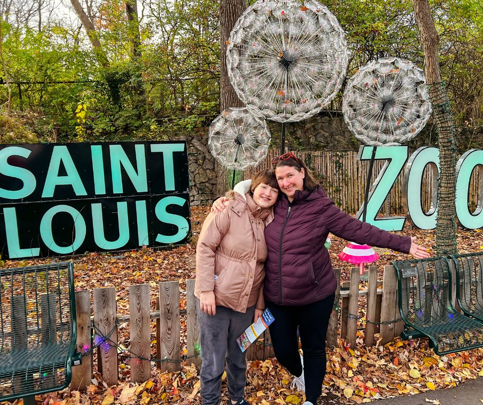 Kim and daughter in front of a Saint Louis Zoo holiday display 