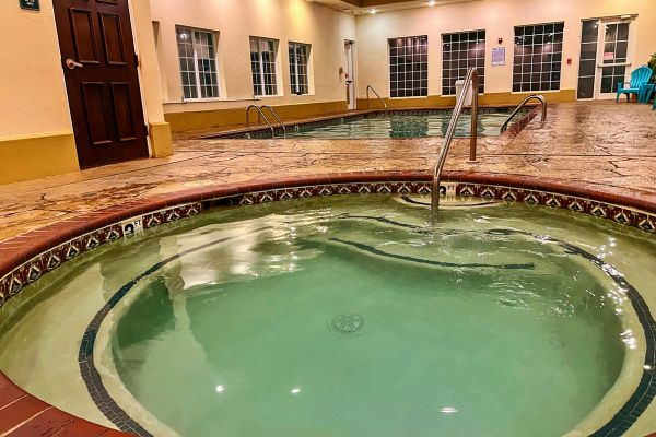 The indoor pool and hot tub at  La Quinta Inn & Suites by Wyndham in Bentonville, Arkansas