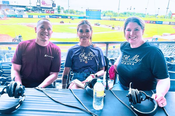 Dave from Wine, Beer & Spirits sits next to Dee and Kim with Werner Park in the background