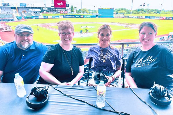 Jay and Leah from Gastronom sit next to Dee and Kim with Werner Park field behind them