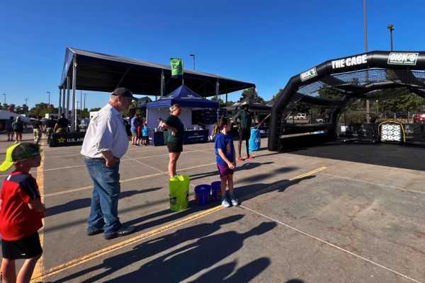 A small group of people stand by a game at Fan Fest in Omaha