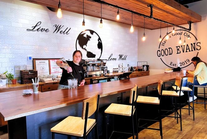 The coffee bar area at Good Evans in Omaha. The back wall says "Live well, Love well"