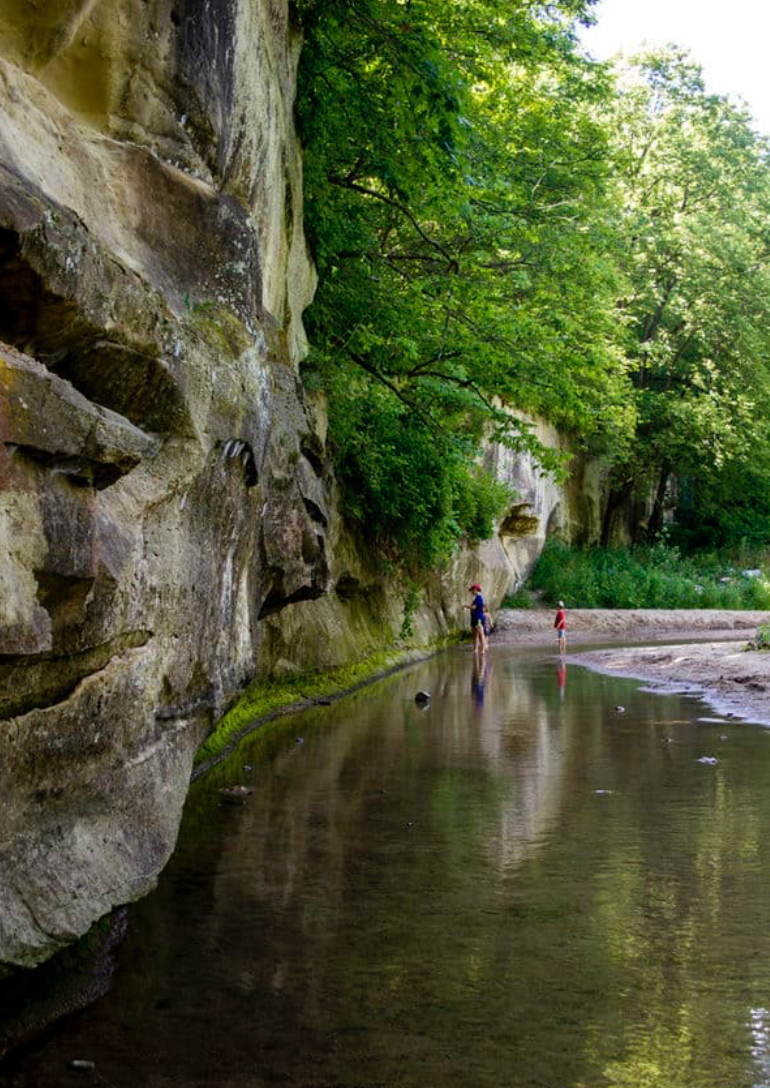 A family stands in a small stream of water at Ledges State Park in Madrid, Iowa