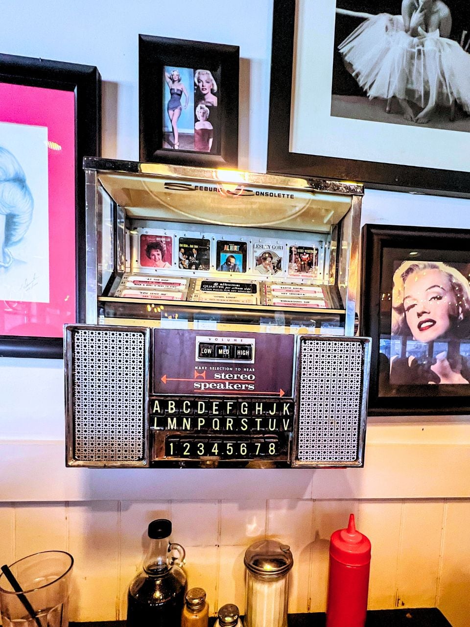 A wall at Shirley's Diner in Omaha, with a small mounted jukebox and Marilyn Monroe pictures