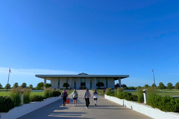 Four people walk toward the Stuhr Building in Grand Island