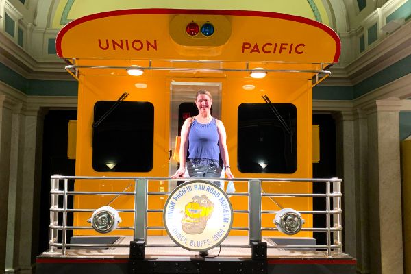 Kim standing on fake caboose photo ops inside the Union Pacific Railroad Museum