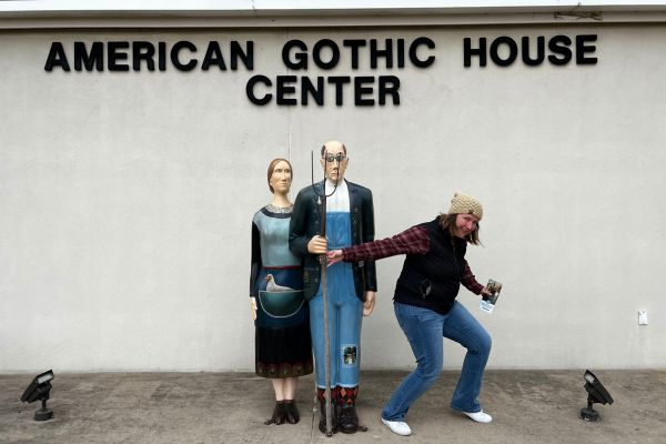 Kim posing with statues in front of the American Gothic House Visitor Center