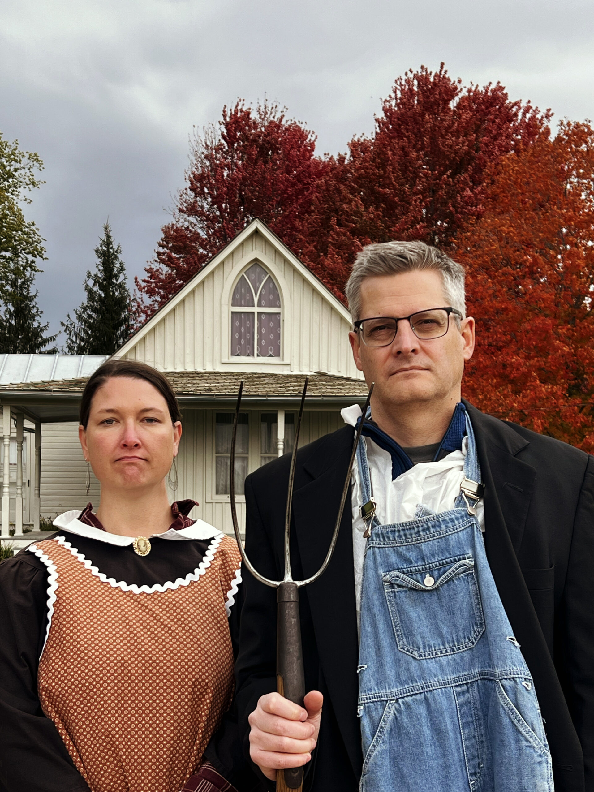 Posing in costumes in front of the American Gothic House in Eldon, Iowa