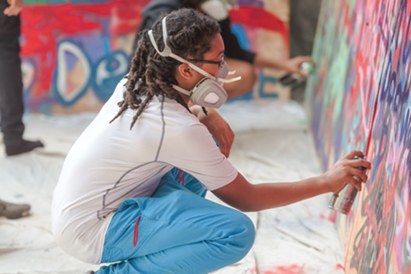 A student uses spray during Hip Hop Lab
