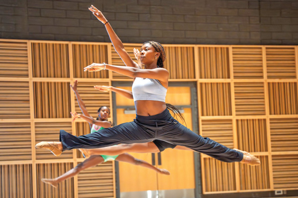 Dancers leap in the air during the Summer Dance Intensive Camp.