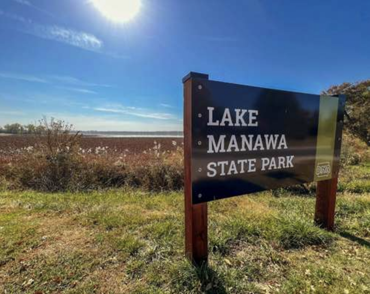 The sign for Lake Manawa State Park with the lake in the background