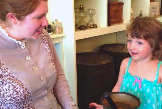 A costumed character talks to a little girl at Living History Farms in Urbandale